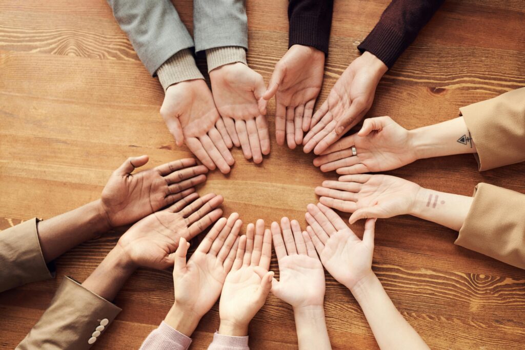 A diverse group of hands joined together in a circle, symbolizing community, unity, and holistic support in recovery