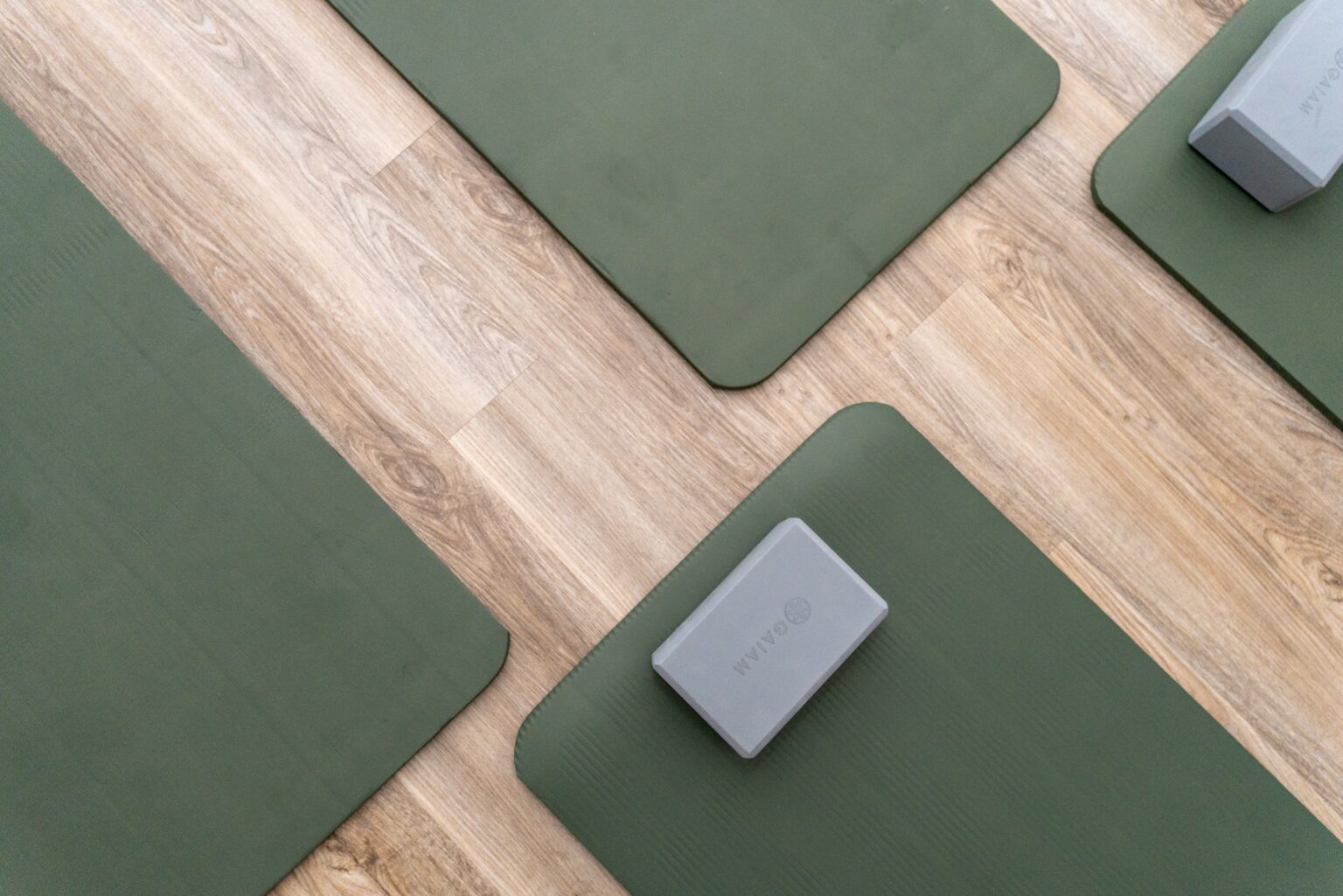 Yoga mats arranged on a wooden floor, emphasizing healing and recovery in a therapeutic setting at Altura Recovery.