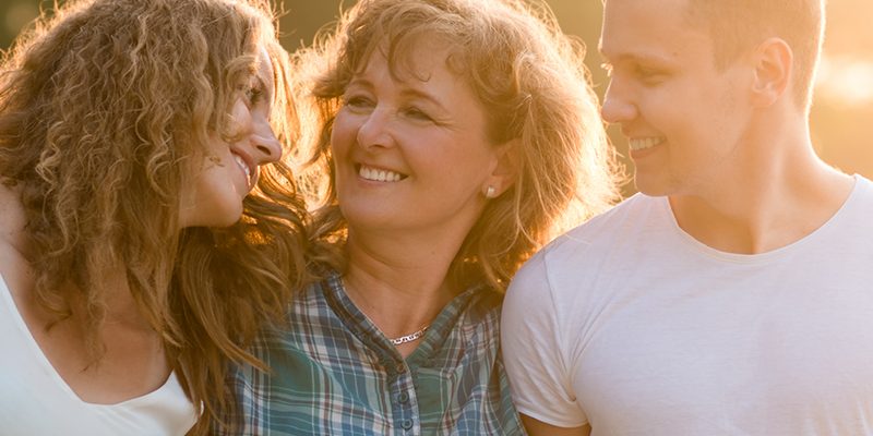 Cheerful happy caucasian family outdoors during summer sunset